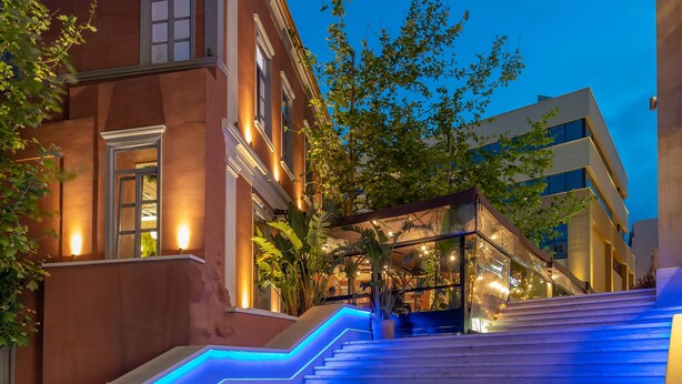 Una escalera iluminada con luz azul que lleva a la entrada de un edificio.