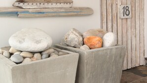 Una jardinera de piedra con rocas y una puerta de madera con el número 18.