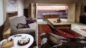 Un salón con sofá, mesa de centro y vistas al mar.