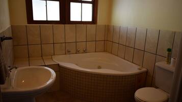Een badkamer met een bad, een wastafel en een toilet.