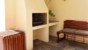A cozy room with a built-in fireplace, a bench, and a wooden stool. - Paul Kruger 63 (Robertson)
