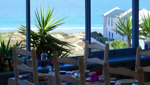 A table set for dining with a view of the sea and a building in the background. - Gilcrest Place (Paternoster)