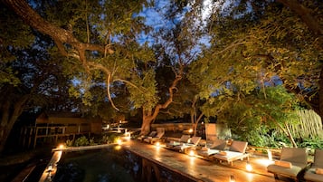 Alberca al aire libre, sombrillas en la alberca y camastros