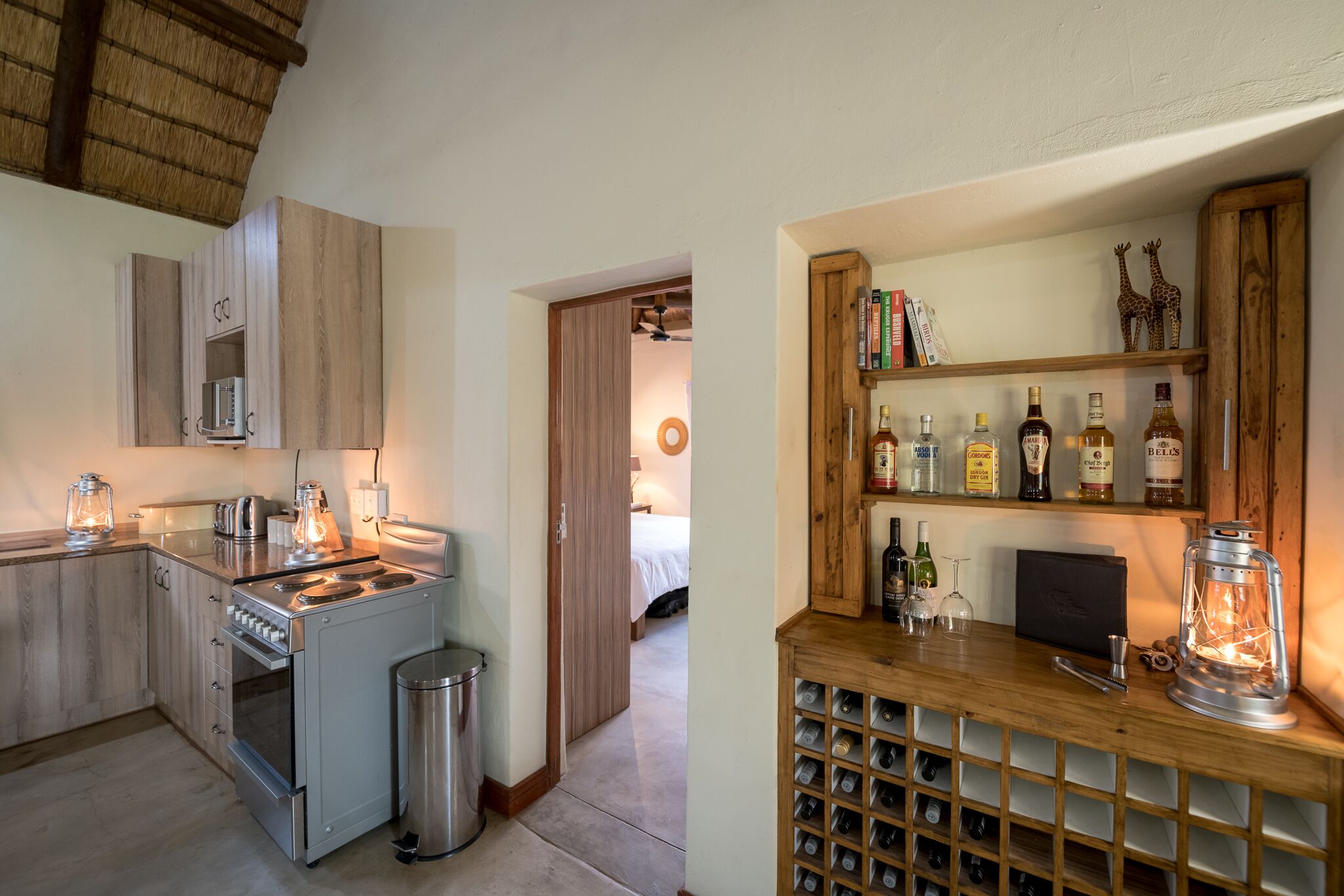 Une cuisine compacte dotée d’appareils électroménagers modernes et d’un meuble à vin contenant des bouteilles.