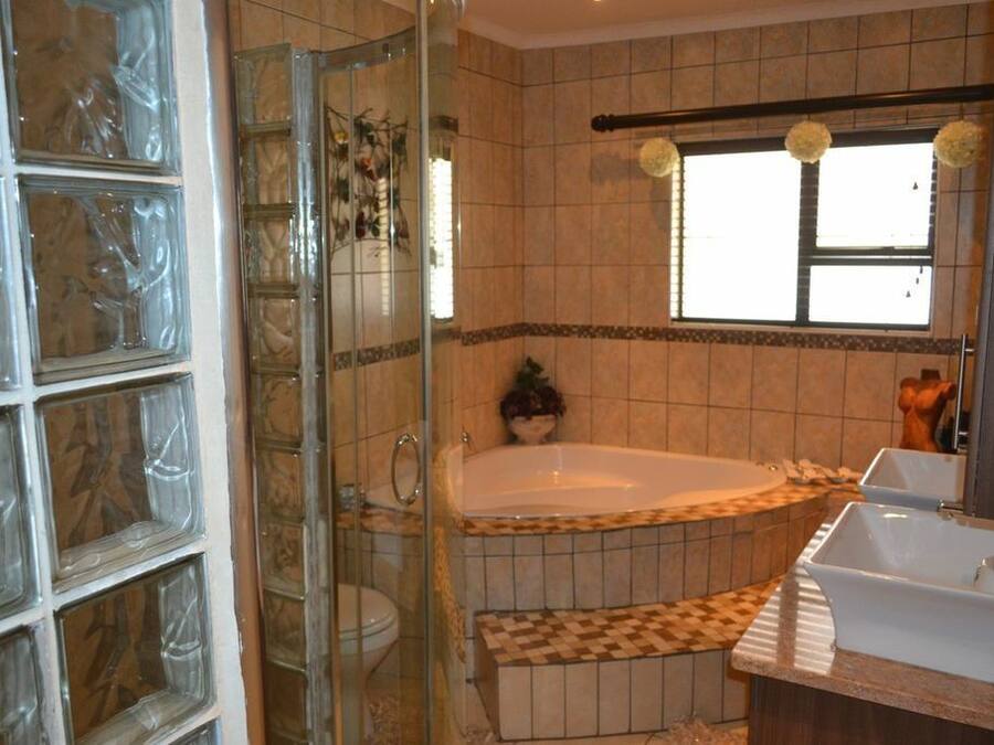 A bathroom with a glass shower enclosure, a freestanding bathtub, and a vanity with a sink.