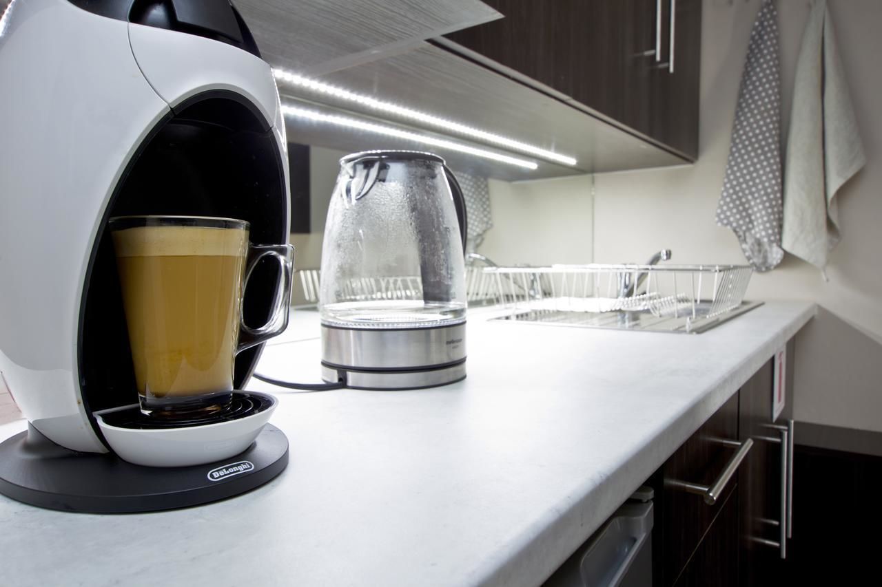 Eine moderne Küche mit Kaffeemaschine, einem Glaskrug und einem Spülbecken.