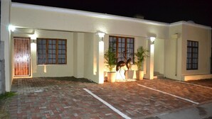 A building with a paved driveway, a wooden door, and a statue. - Faith, Hope & Love (Gqeberha (Port Elizabeth))