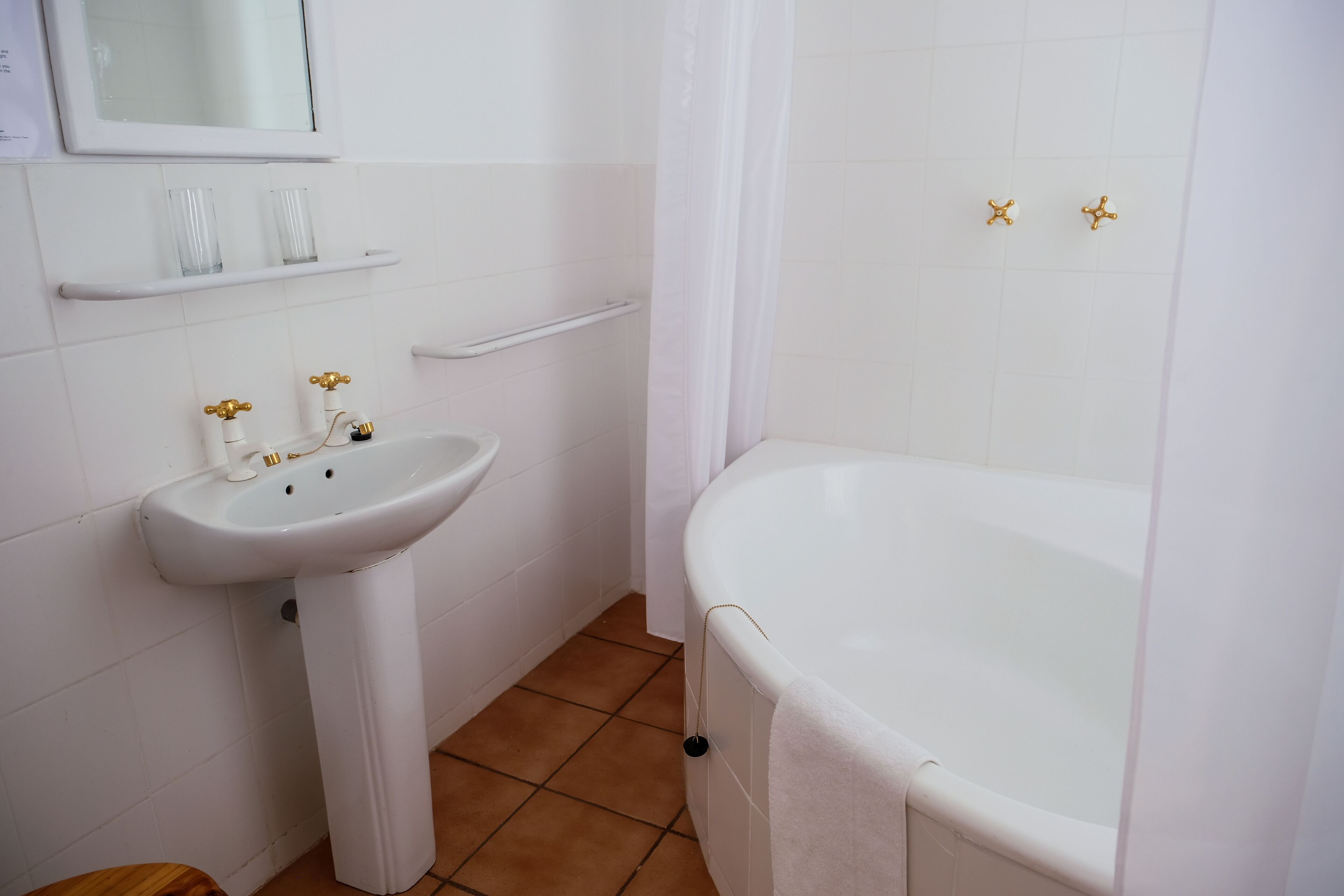 A bathroom with a white sink, a bathtub, and a shower curtain.