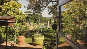 Ein Garten mit Blumentöpfen, einer Pergola und Blick auf das Meer.