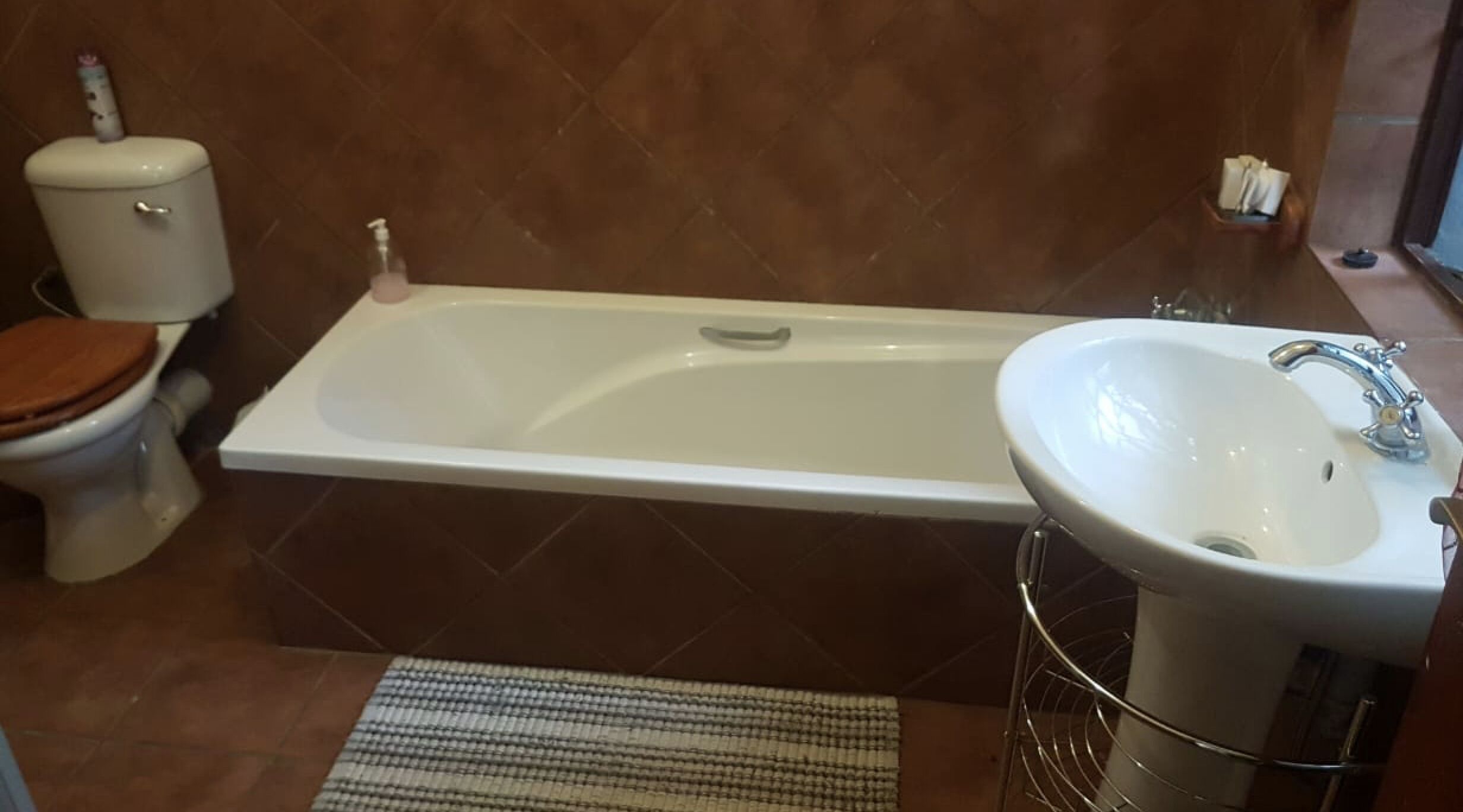 A bathroom with a bathtub, toilet, and sink.