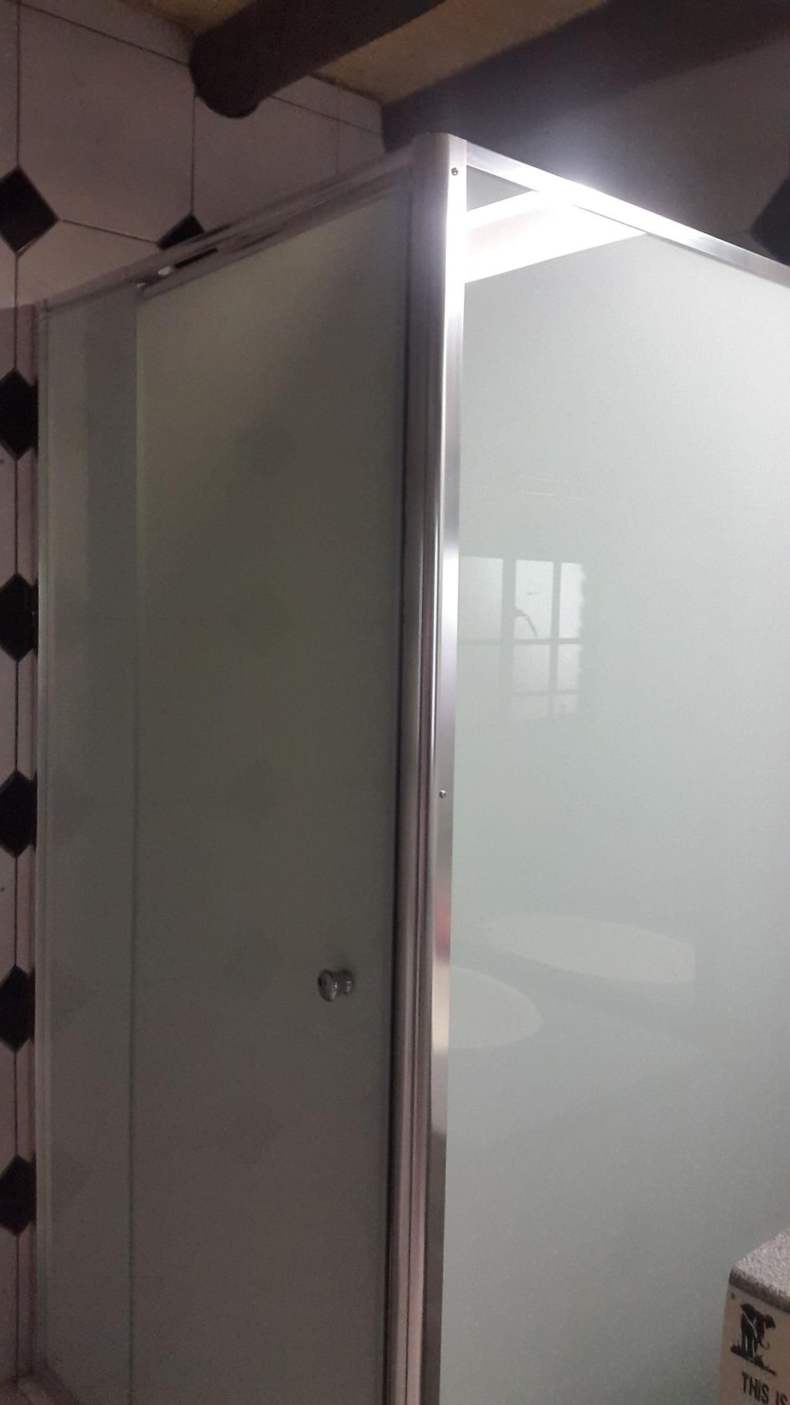 Une pièce dotée d’une porte coulissante, d’un mur carrelé et d’une fenêtre bien visible.