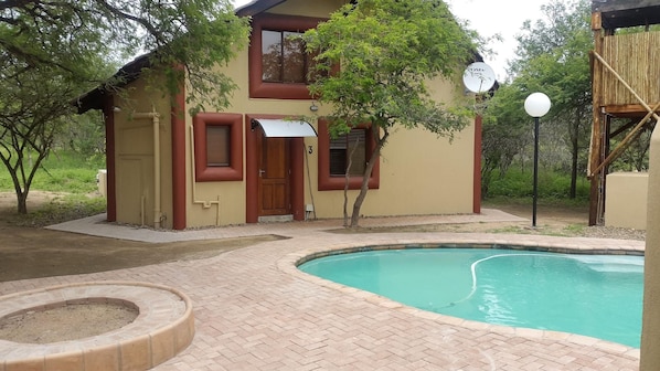 A two-story house with a swimming pool, a covered patio, and a small garden area. - Jabula Lodge (Nkomazi)