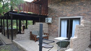 Un patio con un banco de piedra, una mesa y una silla.