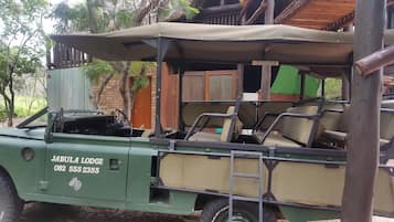 Un véhicule de safari vert, équipé d’un toit, portant l’inscription « JABULA LODGE » et un numéro de téléphone.