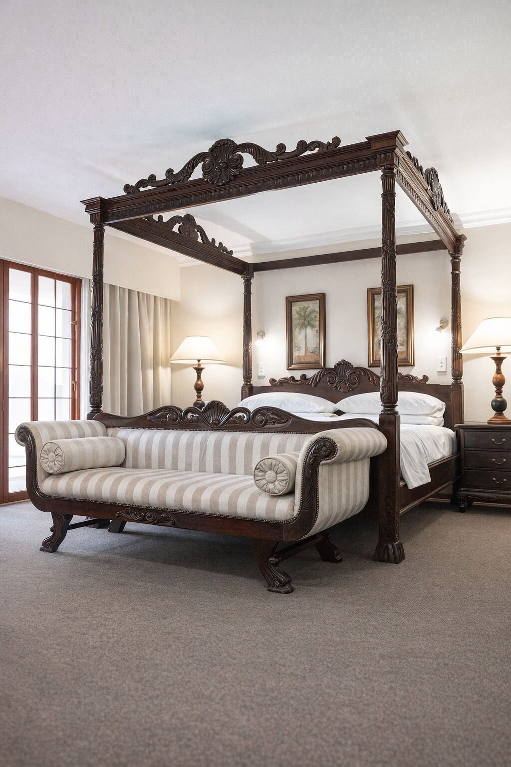 A four-poster canopy bed with a striped upholstered sofa, a wooden nightstand, and two wall-mounted lamps.