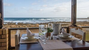 Een tafel voor twee met uitzicht op de oceaan en een rotsachtige kustlijn.