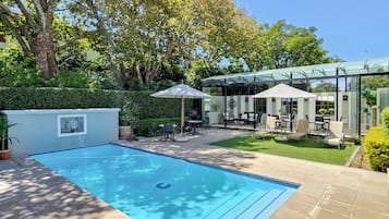 Piscine extérieure, parasols de plage, chaises longues