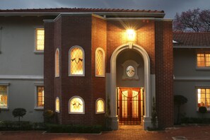 A two-story building with a brick facade, arched windows, and a gated entrance. - Brooklyn Place Guesthouse (Pretoria)