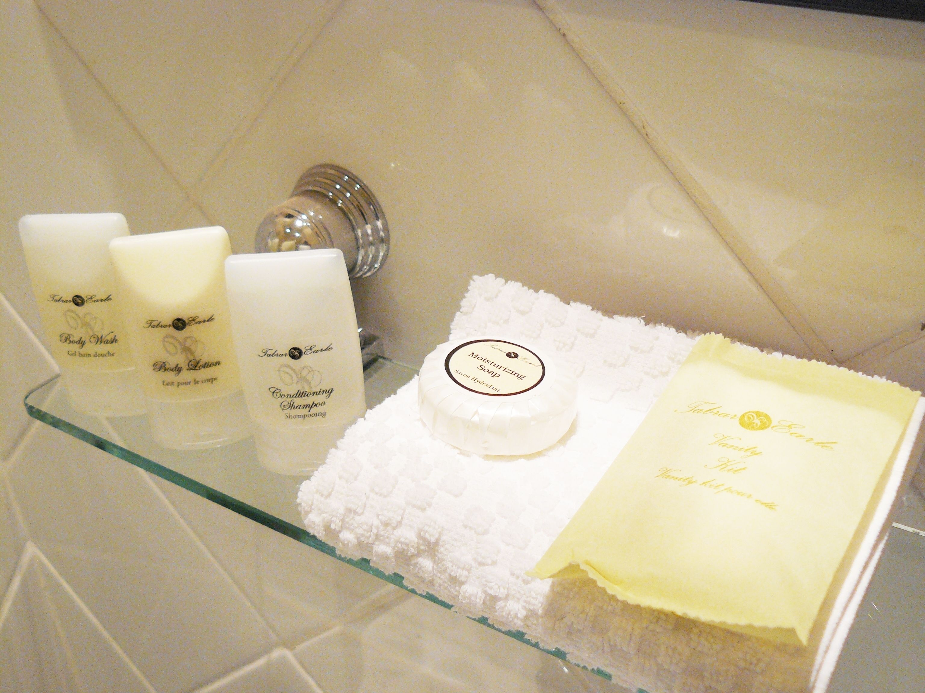 A bathroom shelf with toiletries including body wash, lotion, and soap.