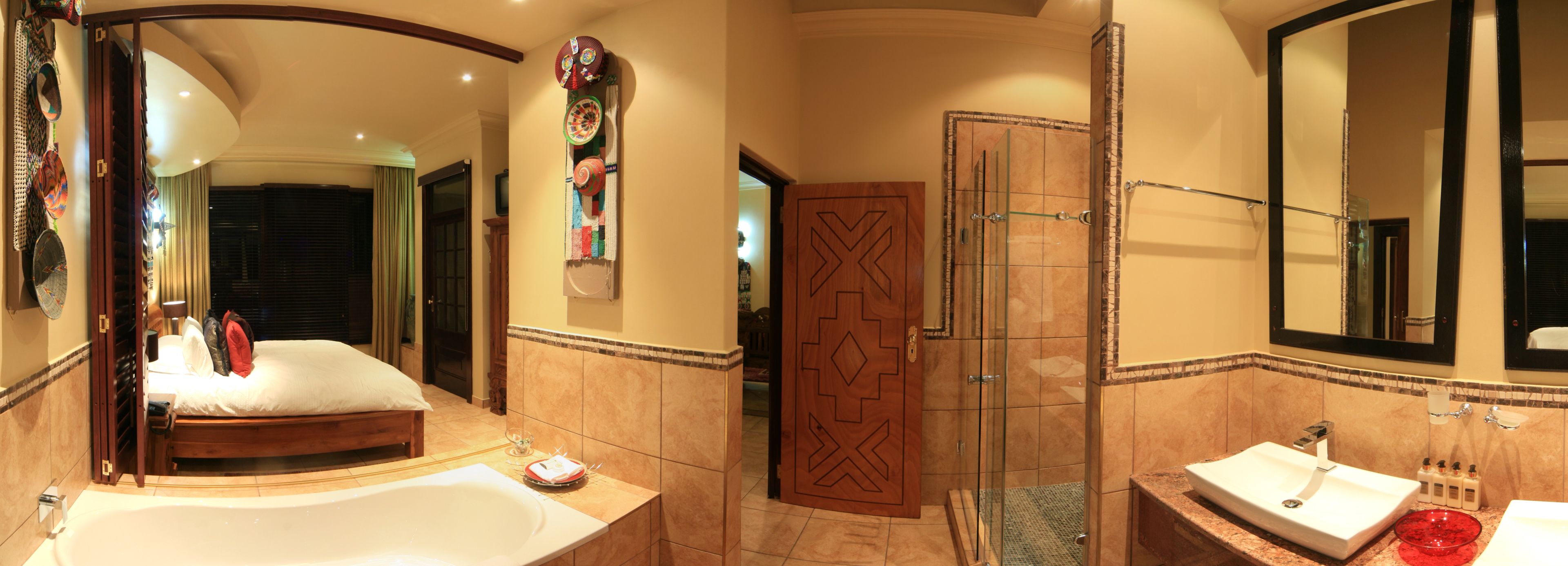 A spacious bathroom with a large bathtub, a glass shower enclosure, and a vanity with a red bowl sink.