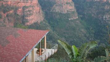 A building with a red roof and a balcony overlooking a canyon.