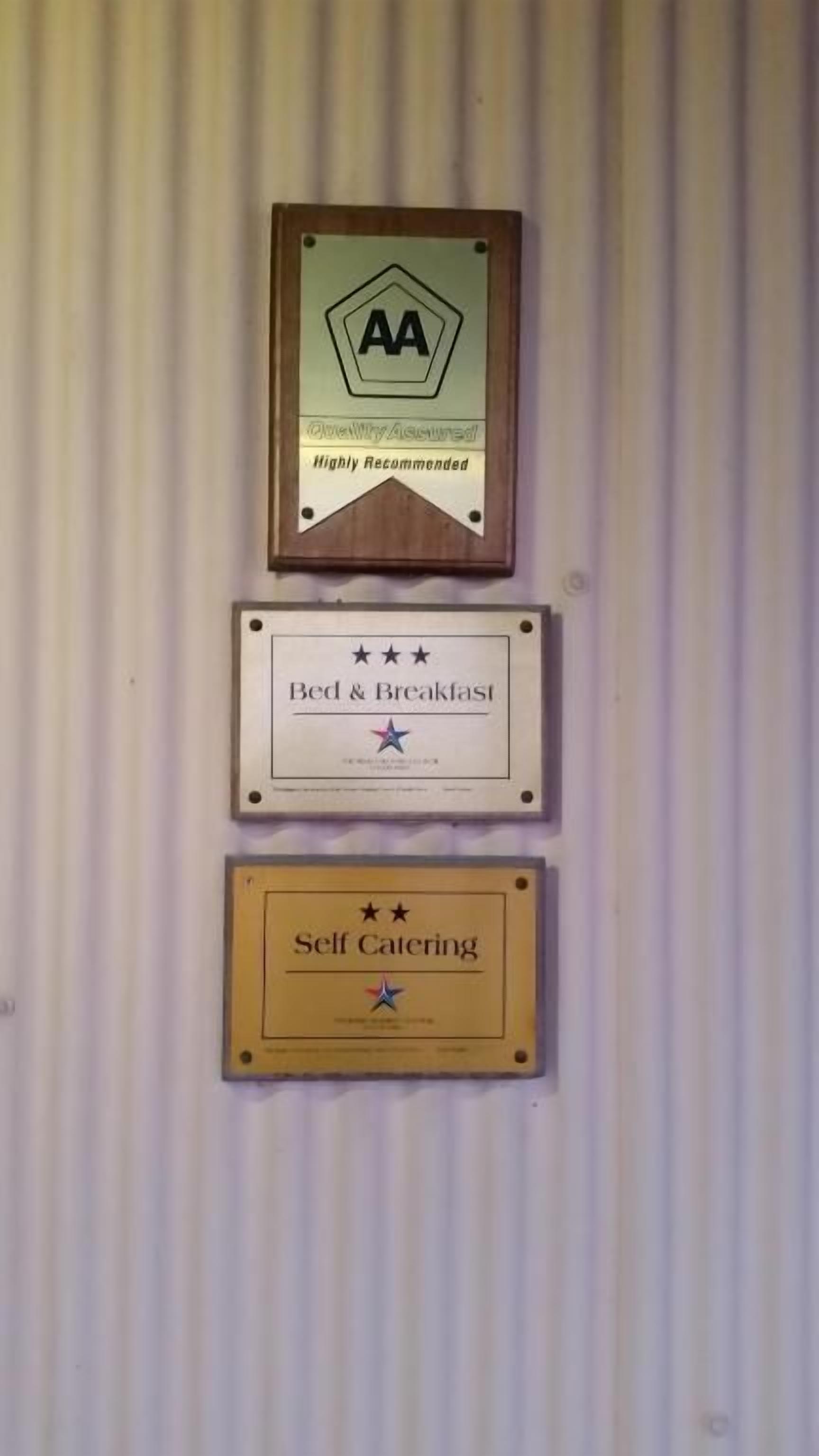 Three plaques on a wall, each with different text and symbols.