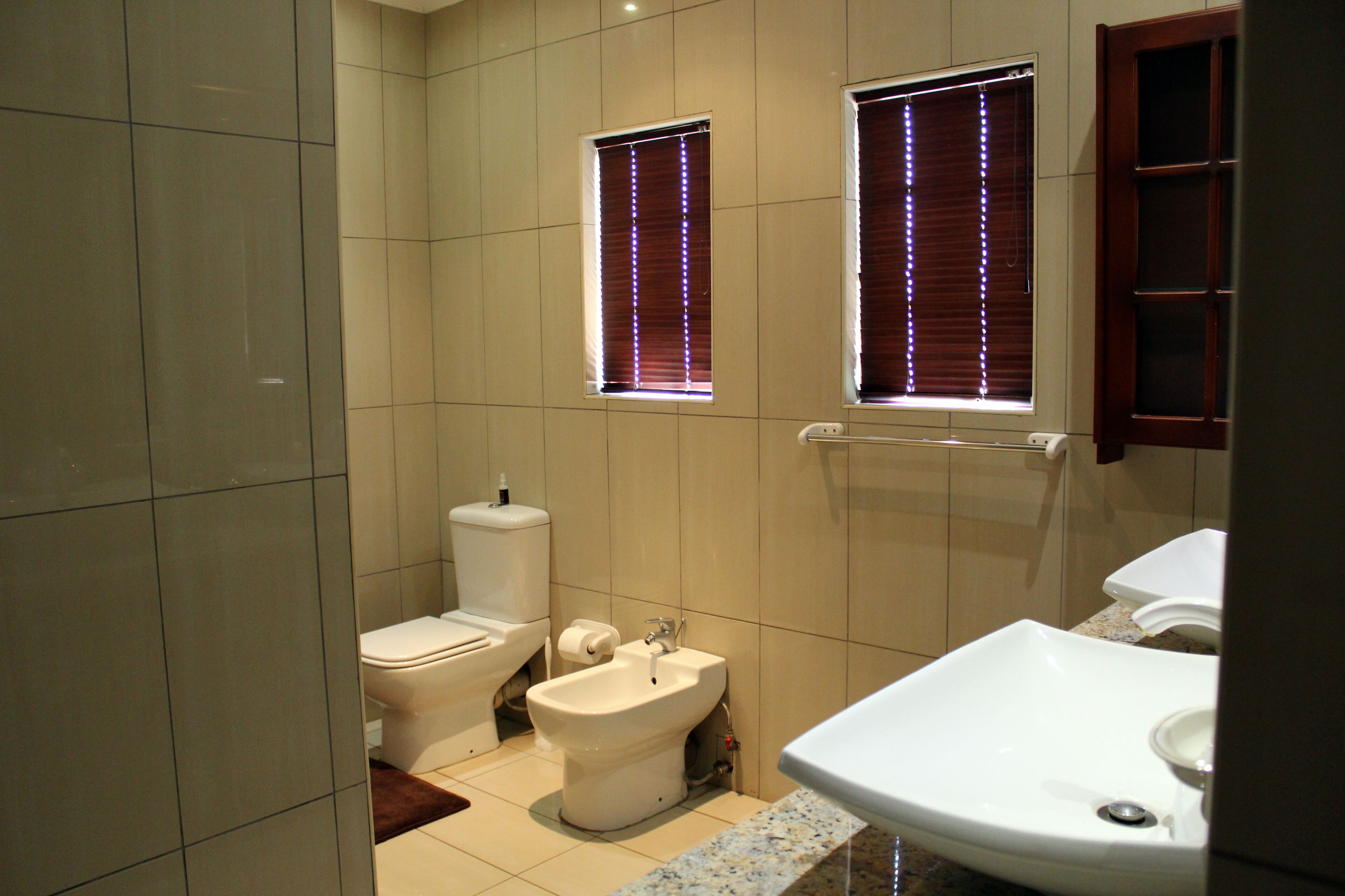 Un baño con inodoro, bidé y lavabo.
