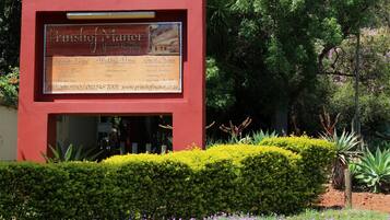Cartel de Prishof Manor que enumera servicios como sede para eventos corporativos, lugar para bodas y casa de huéspedes.