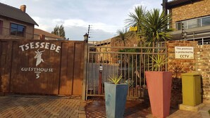 A gated entrance with a wooden sign reading "TSSSEBE GUESTHOUSE 5". - Tsessebe Guesthouse (Bloemfontein)