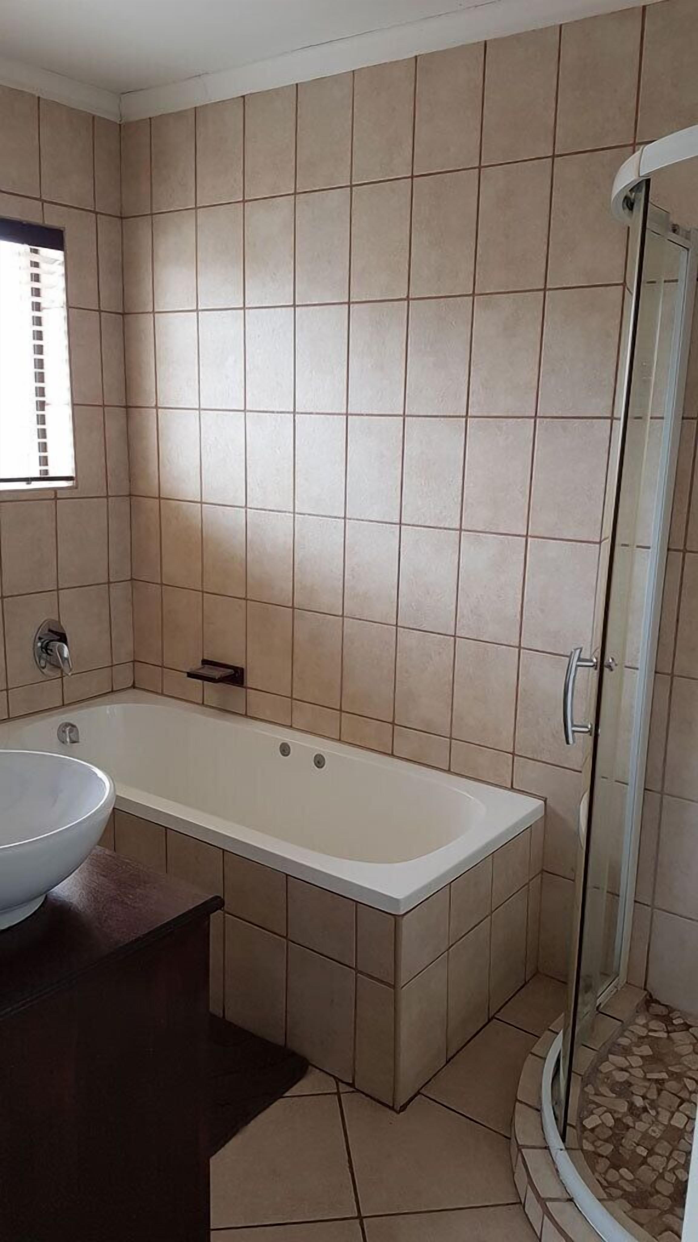 Ein Badezimmer mit einer Badewanne, einem Waschbecken und einer Duschkabine.