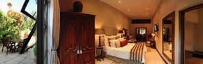 Ein Schlafzimmer mit Bett, Nachttischen, einem Kleiderschrank und einem großen Spiegel.