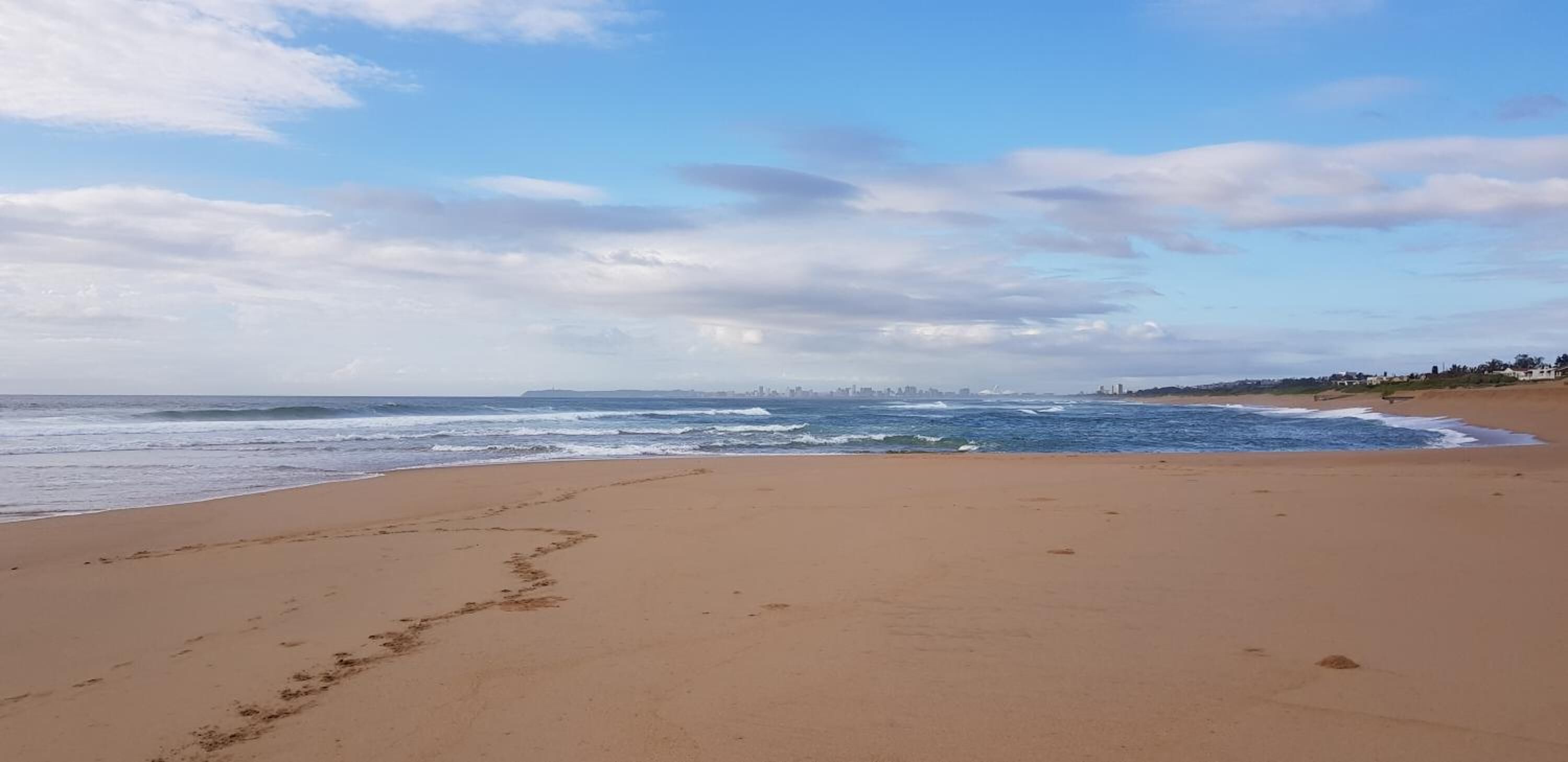 Una playa con cielo despejado y olas.