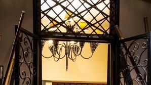 Eine verzierte Tür mit einem Chandelier, einem Blumenbild und einer Statue im Kamin.