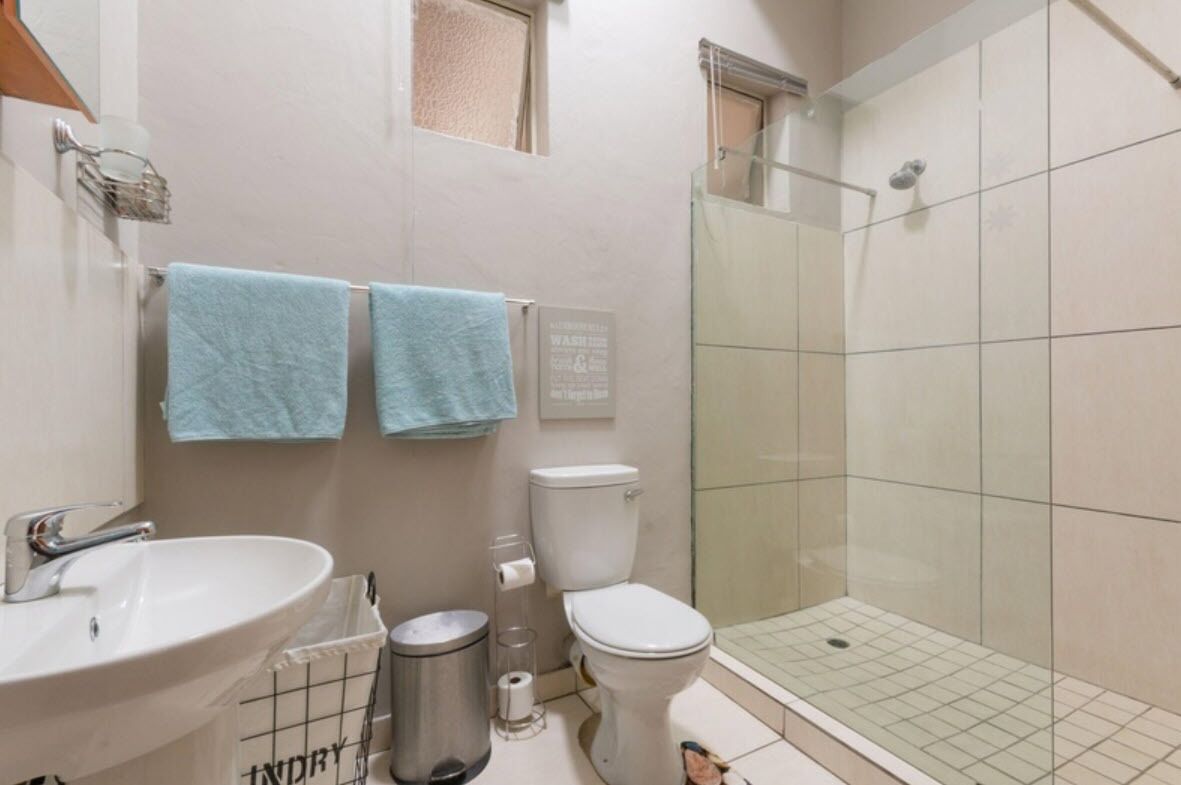 A bathroom with a sink, toilet, and glass-enclosed shower.