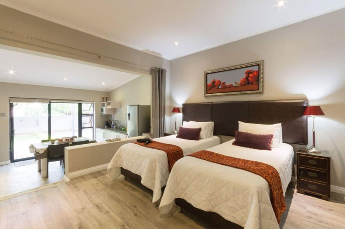 Une chambre d’hôtel avec deux lits, un coin repas et une vue sur l’extérieur.