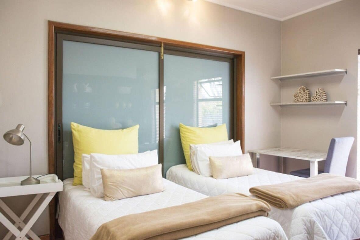 Habitación de hotel con dos camas, un escritorio y una silla.