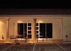 A covered outdoor area with a fire, columns, and a bench. - Ya Rena Guesthouse (Groblersdal)