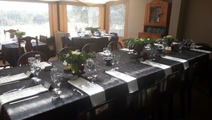 A restaurant with tables set for dining, featuring name cards and wine glasses. - A Little Guesthouse (Bloemfontein)