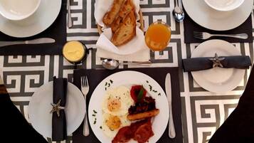 A breakfast setting with toast, eggs, bacon, and a side of fruit.
