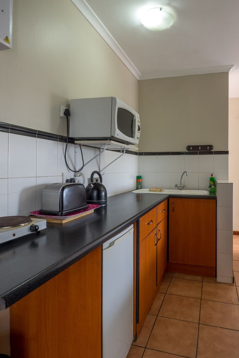 Eine kleine Küche mit Mikrowelle, Toaster, Wasserkocher und Spüle.