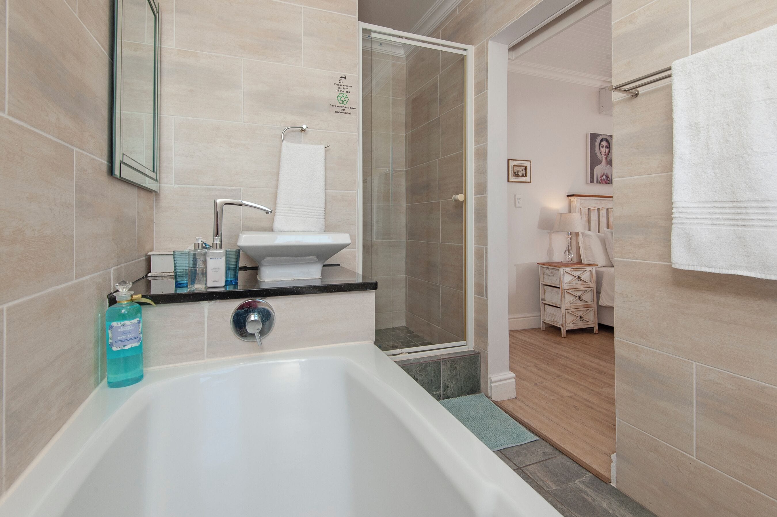 A modern bathroom with a bathtub, sink, and glass shower enclosure.