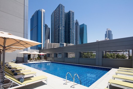 Outdoor pool, pool umbrellas, sun loungers. Rove Trade Centre