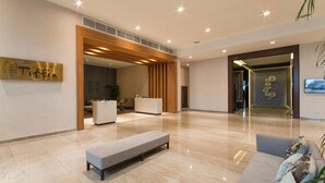 A spacious lobby with a reception desk, a bench, and a sofa. - Impiana Hotel Senai (Senai)