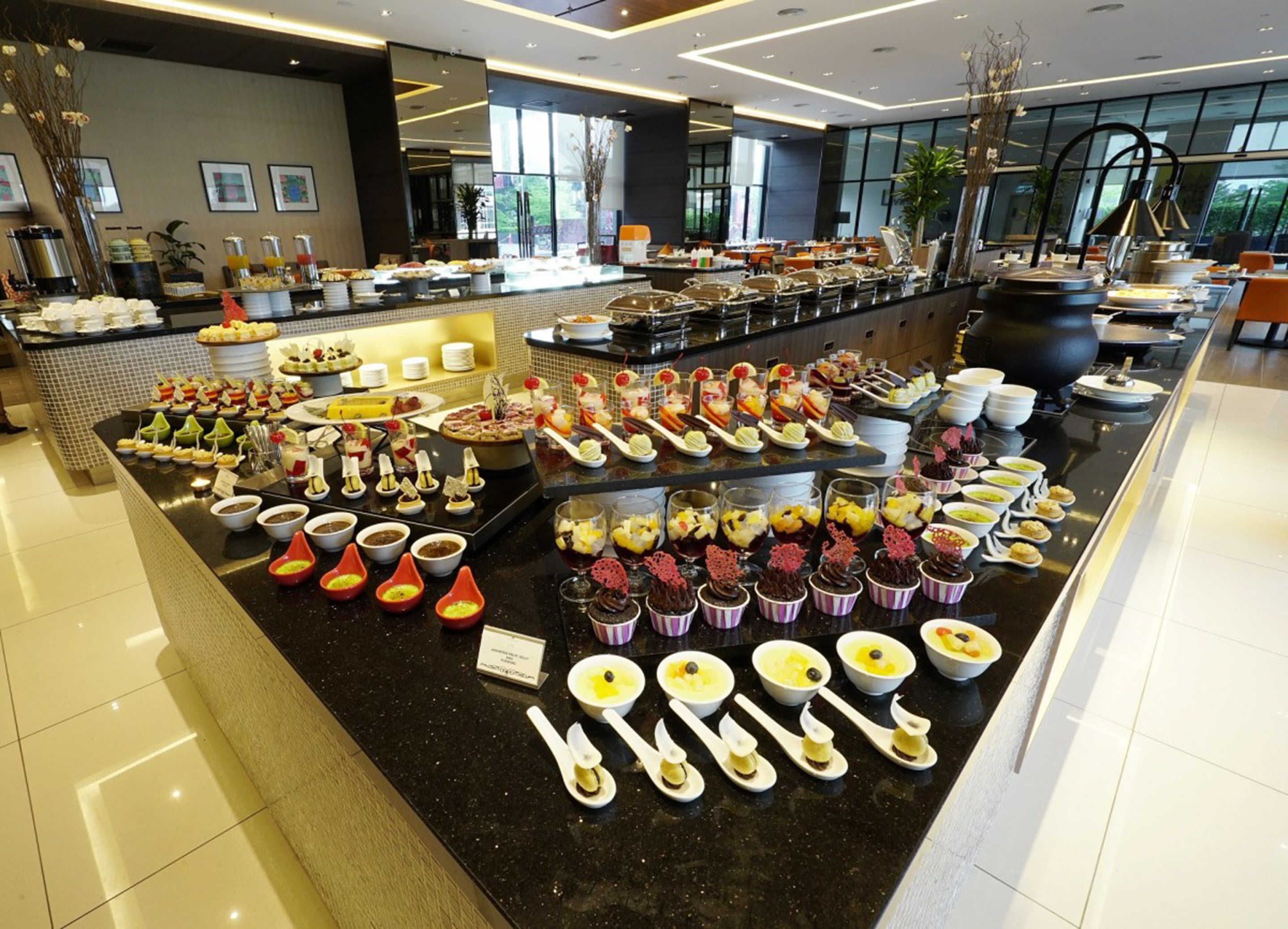 A buffet with various food items and utensils.