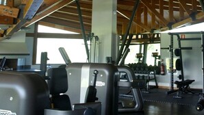 Un gimnasio con diverso equipo de ejercicio, incluyendo máquinas de pesas y mancuernas.