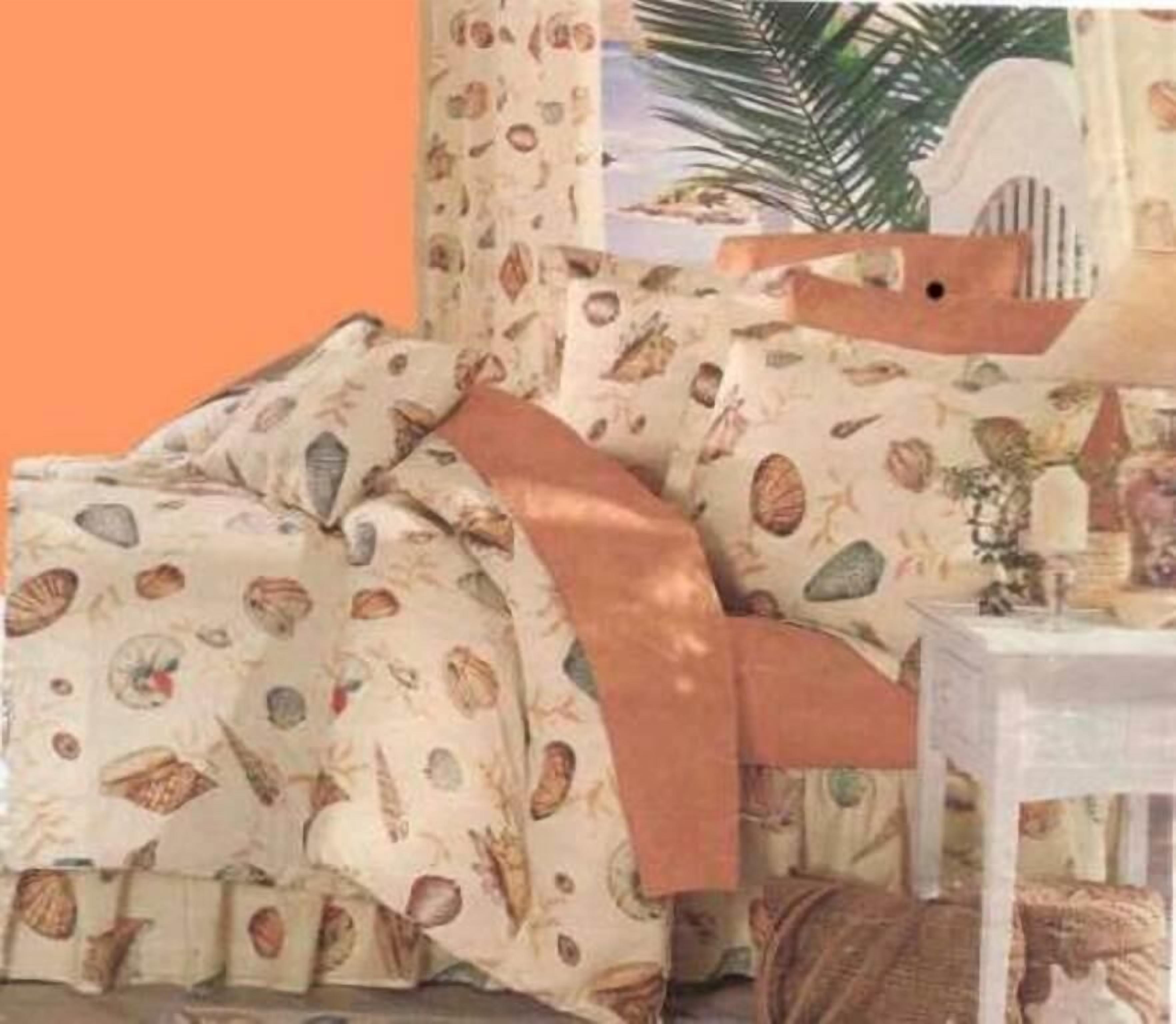 A bedroom with a bed covered in a patterned duvet, a bedside table with a lamp, and a window with curtains.