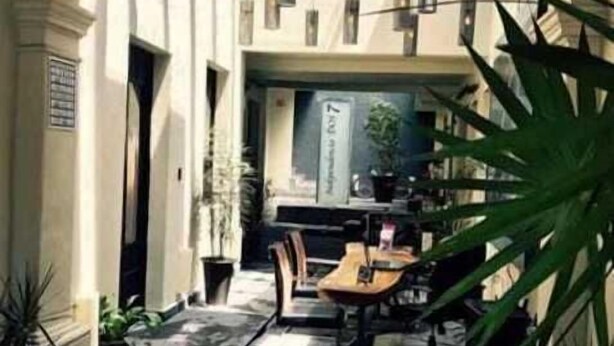 An outdoor café with tables and chairs, potted plants, and a wooden ceiling. - Independencia Dos 7 Hotel Boutique (Querétaro)