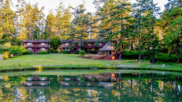 A lakeside lodge with multiple buildings, a gazebo, and a reflection in the water. - Captain Whidbey (Coupeville)