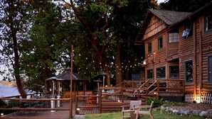 A wooden cabin with a deck, outdoor seating, and a gazebo. - Captain Whidbey (Coupeville)