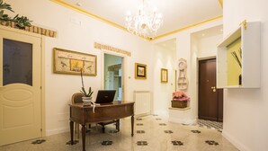 A hallway with a piano, framed artwork, a clock, and a mirror. - Trastevere Royal Suite (Rome)